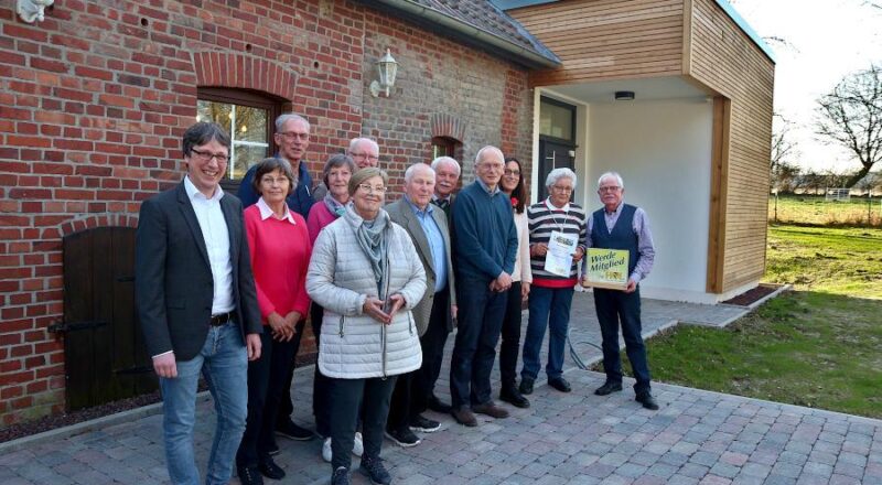 Bürgermeister Martin Hoffmann, Hildegard Hanning Bernd Hoffmann, Kassiererin Margret Winter, Archivarin Inge Hoffmann, Ehrenvorsitzender Rudi Strunk (dahinter), Ex-Kassierer Hans-Joachim Herrmann, Ehrenvorsitzender Helmut Eikermann, Dieter Tamm, Kerstin Koppmann, Geehrte Helga Wächter und Vorsitzender Helmut Depping haben sich von dem Backhaus und seinen neuen Anbau zum Foto aufgestellt. Foto: Thomas Dohna