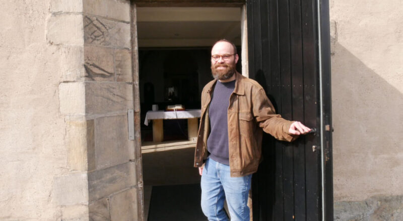 Mit der Bibel im Hintergrund: Benjamin Braun ist Vikar in der ev.-ref. Kirchengemeinde Heiligenkirchen. Foto: Lippische Landeskirche