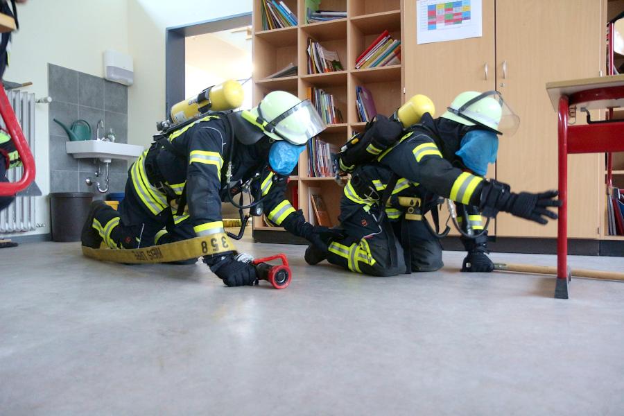 Die Feuerwehrleute sehen kaum etwas. Sie sollen den Klassenraum nach einem Menschen absuchen. Foto: Thomas Dohna