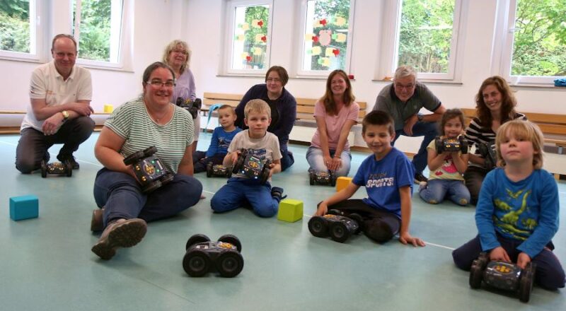 Eltern, Kinder und Mitarbeiterinnen der Kita Greste erleben unter der Leitung von Reinhard Stückerjürgen (hinten links) einen Nachmittag mit programmierbaren Robotern. Foto: Thomas Dohna