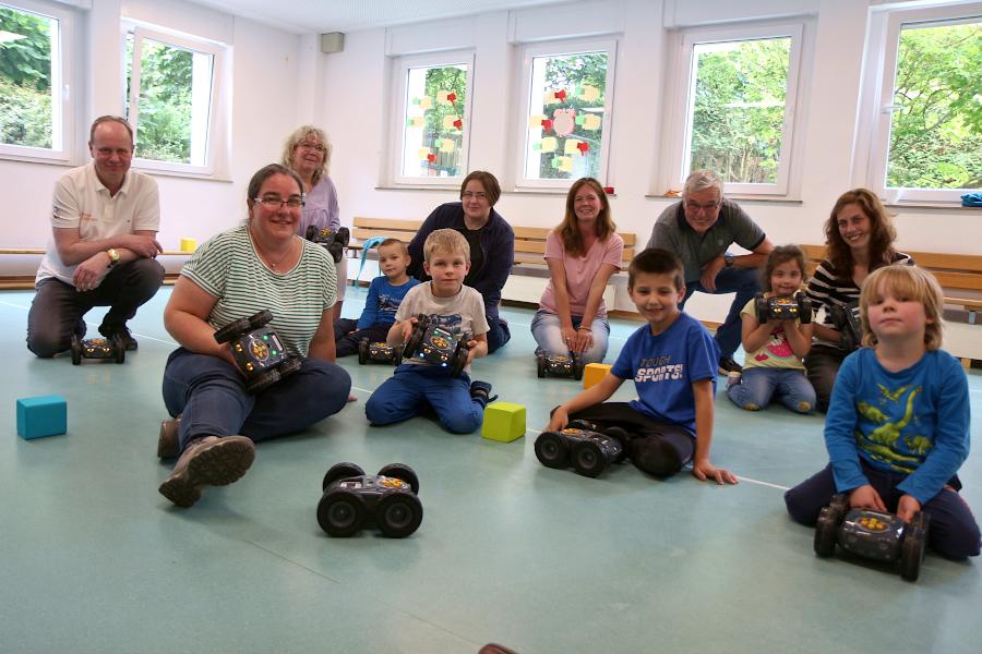 Eltern, Kinder und Mitarbeiterinnen der Kita Greste erleben unter der Leitung von Reinhard Stückerjürgen (hinten links) einen Nachmittag mit programmierbaren Robotern. Foto: Thomas Dohna