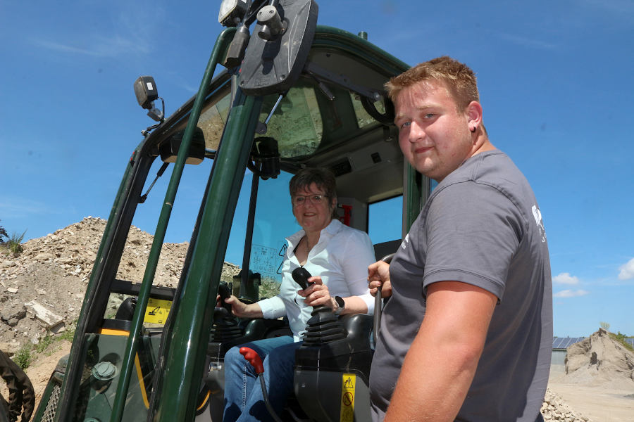 Monika Kopetsch lässt sich auf dem Gelände des Garten- und Landschaftsbauers Wiebusch von Max-Leon Trieb den Bagger erklären - und baggerte dann auch selbst. Foto: Thomas Dohna