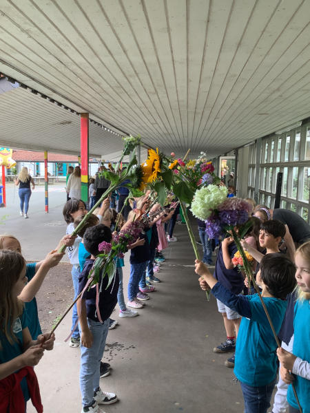 Alle Schülerinnen und Schüler hatten Blumen mitgebracht und stellten sich zur Verabschiedung der Viertklässler zum Spalier auf. Foto: Privat