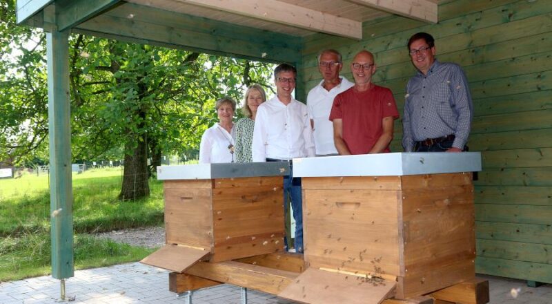 Guido Letmathe (im roten Shirt) betreut den Bienenlehrstand auf dem Heimathof. An der Vorstellung des Standes nahmen Inge Hoffmann vom Heimatverein (von links), Susanne Weißhaupt (3L-leader-Region), Bürgermeister Martin Hoffmann, Bernd Hoffmann (Heimatverein) und Michael Kiszan (Gemeindeverwaltung). Foto: Thomas Dohna