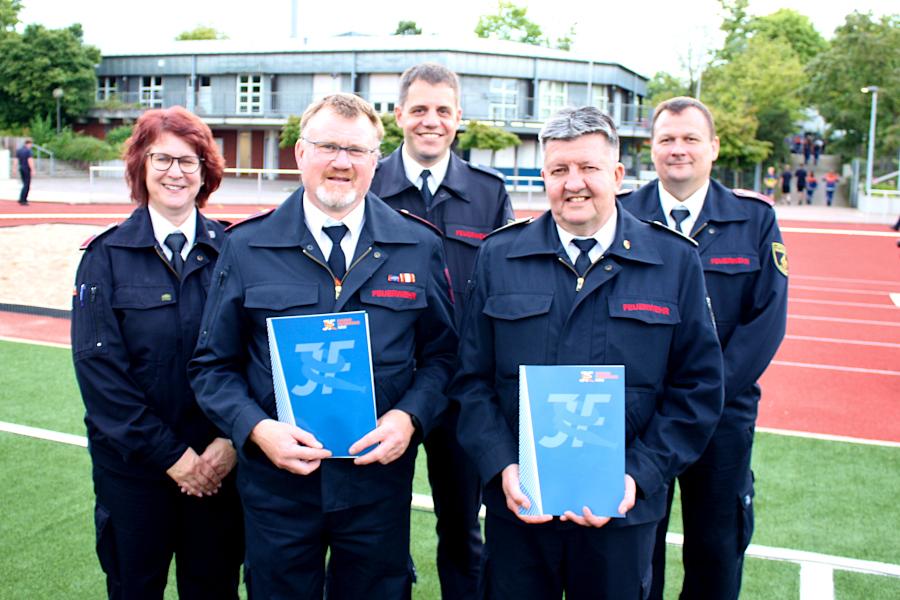 Für ihre Verdienste um die Jugendfeuerwehr bekamen Stefan Wendt (vorn links) die Ehrennadel in Silber und Detlef Kreutz (rechts) die Ehrennadel in Gold. Kreisjugendfeuerwehrwartin Heike Lalk, Nico Ahle vom Landesfeuerwehrverband und der Stellvertretende Kreisjugendfeuerwehrwart Jan Althöfer (hinten von links) zeichneten die Geehrten aus. Foto: Thomas Dohna