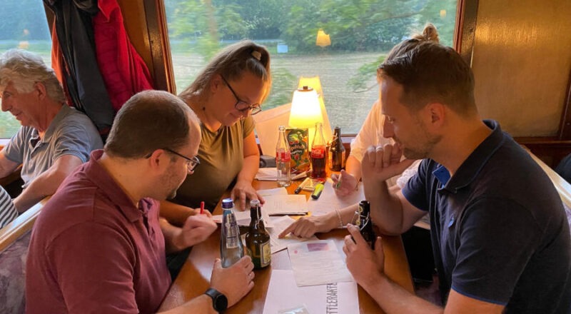 Ein Ermittlerteam versucht gespannt den Krimifall in der Museumseisenbahn zu lösen. Foto: Kulturstellwerk Nordlippe