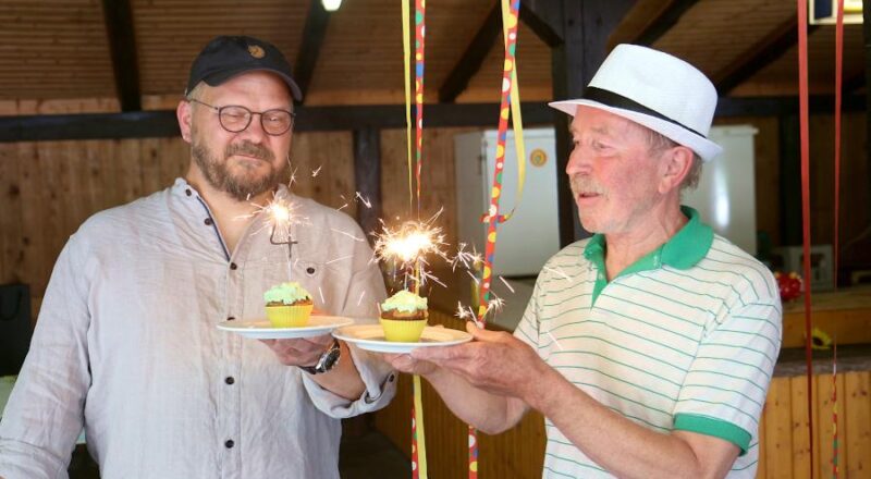 Andreas Puchert, Co-Vorsitzender des Ortsverbandes der Grünen (links) und Ulrich Lasar, Mitgründer der Grünen in Leopoldshöhe, halten zwei Küchlein mit einer Vier und einer Null, geformt aus Wunderkerzen. Foto: Thomas Dohna