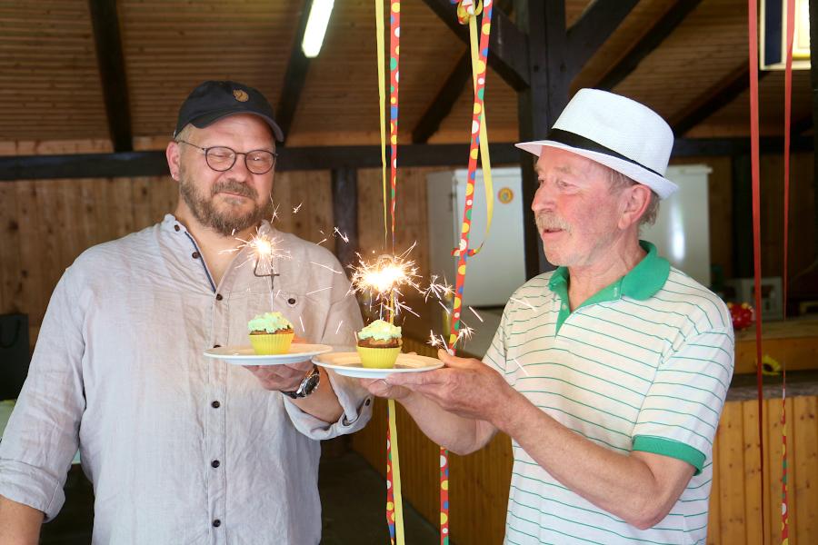 Andreas Puchert, Co-Vorsitzender des Ortsverbandes der Grünen (links) und Ulrich Lasar, Mitgründer der Grünen in Leopoldshöhe, halten zwei Küchlein mit einer Vier und einer Null, geformt aus Wunderkerzen. Foto: Thomas Dohna