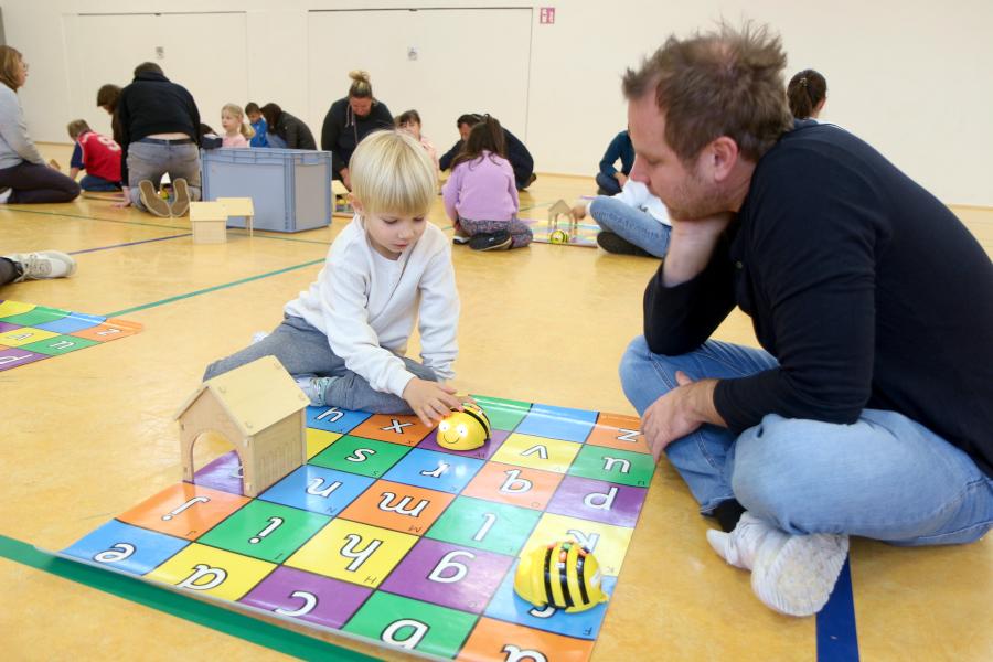 Milo programmiert eine Roboterbiene. Vater Mathis schaut zu. Foto: Thomas Dohna