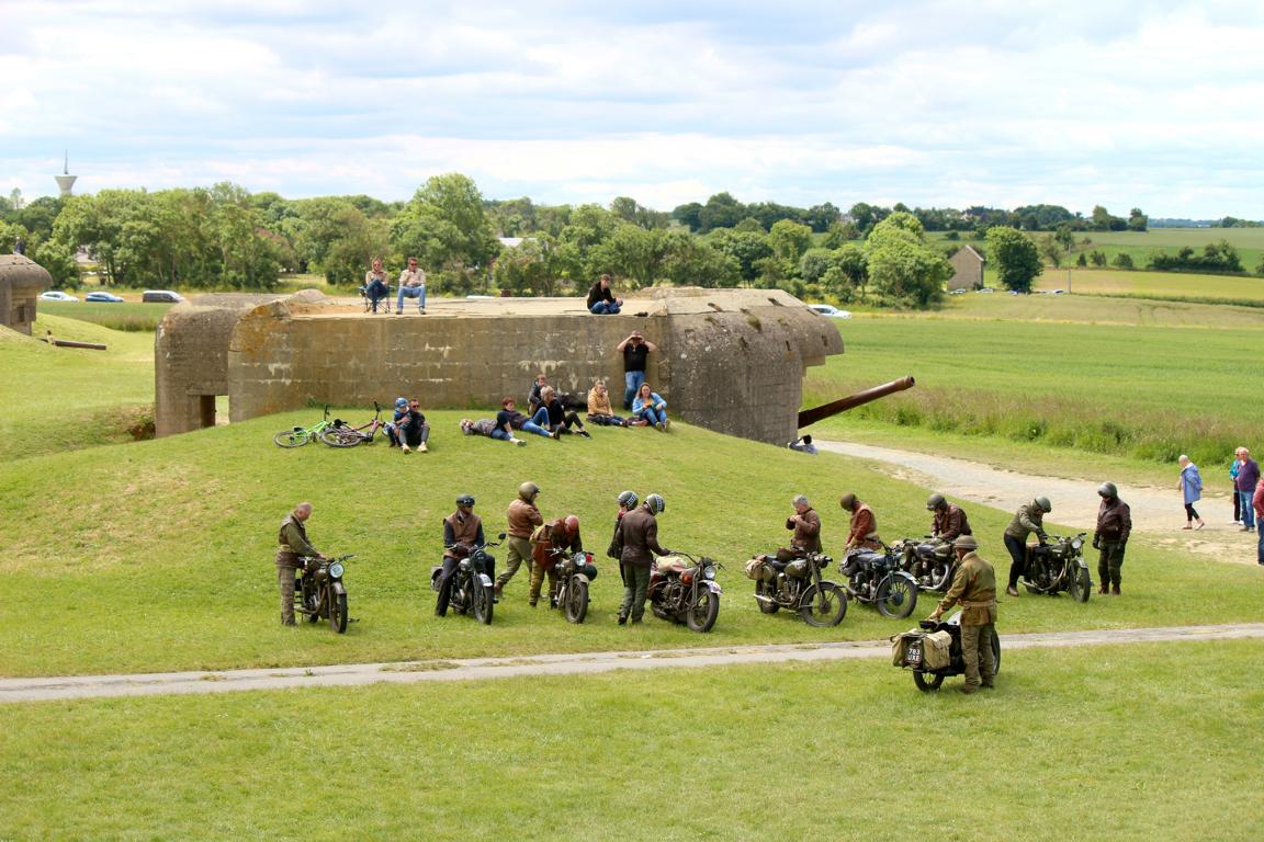 An einem Artillerie-Bunker des Atlantik-Walls haben sich britische Motorradfahrer mit ihren historischen Maschinen versammelt. Foto: Thomas Dohna