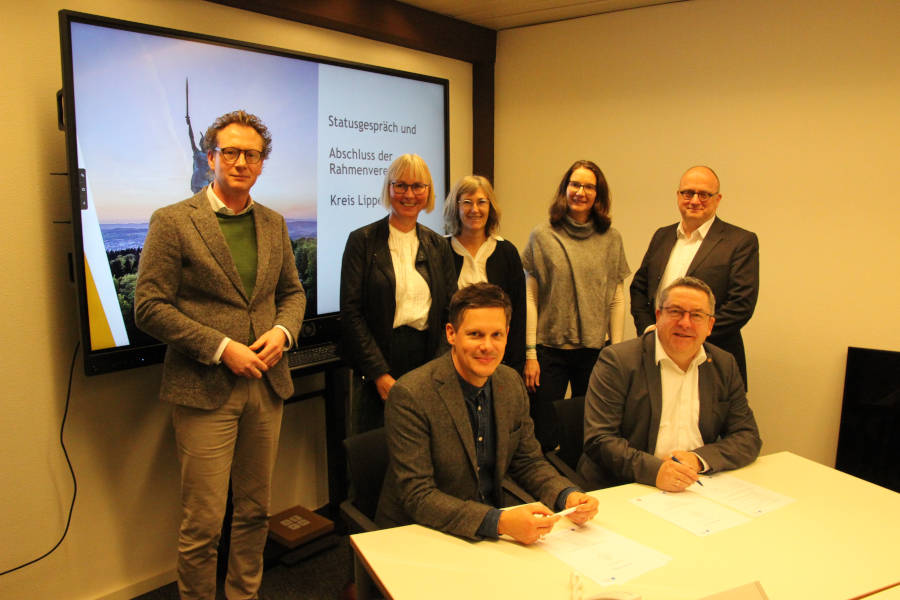 Landrat Dr. Axel Lehmann (vorn rechts) und Dr. Mario Roland, Leiter der REAB NRW (vorn links), unterzeichnen die Rahmenvereinbarung zur Zusammenarbeit im Beisein von Verwaltungsvorstand Dr. Olaf Peterschröder (hinten von links), Anja Krause (Kreis Lippe), Kirsten Althoff (REAB NRW), Dr. Claudia Böhm-Kasper und Dirk Menzel (beide Kreis Lippe). Foto: Kreis Lippe