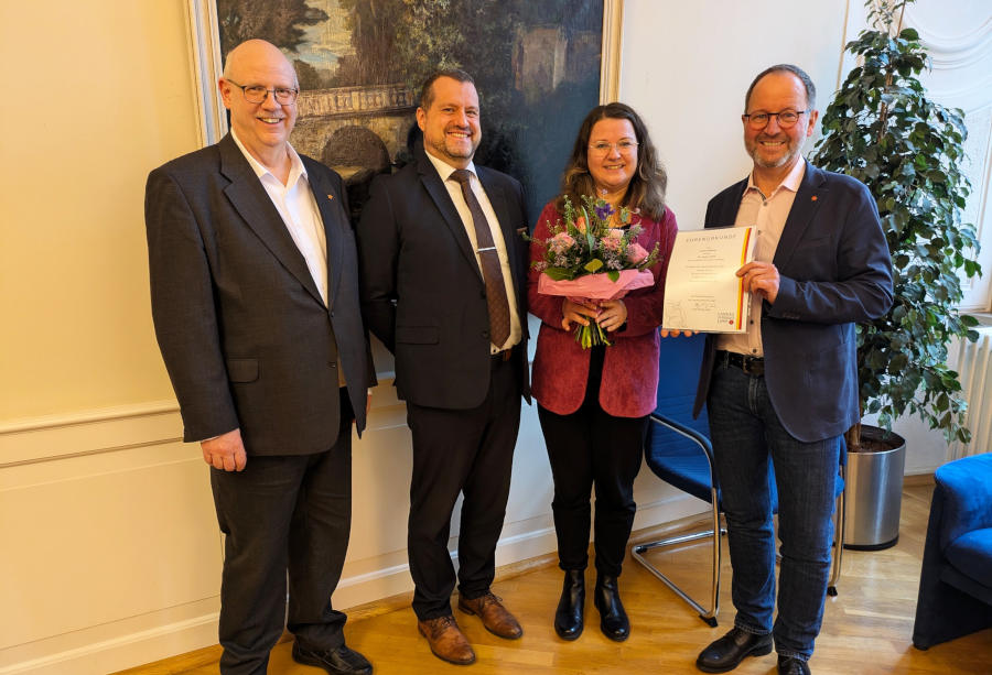 Durfte sich über eine Urkunde und Blumen zum 25-jährigen Dienstjubiläum freuen: Sandra Rehberg mit (v.r.) Verbandsvorsteher Jörg Düning-Gast, Verbandskämmerer Marcos Canosa und Andreas Tewes, Leiter des Fachbereichs Personal & Organisation. (Foto: LVL)