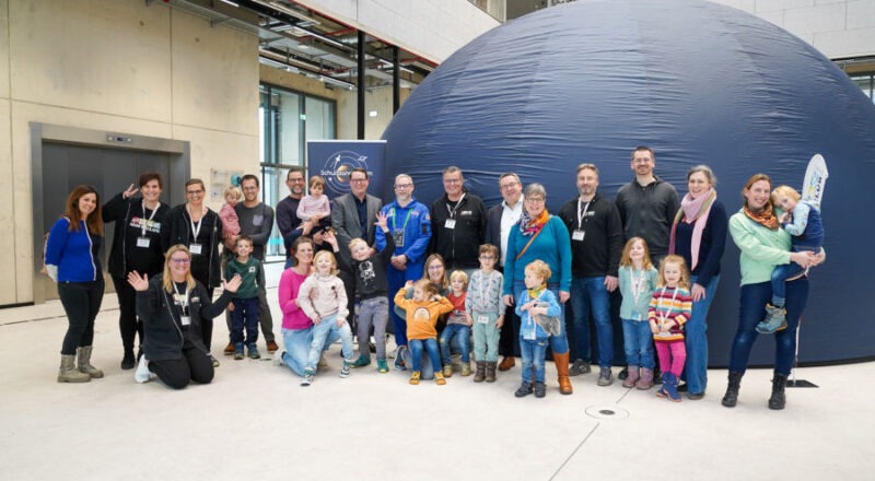 Vorfreude auf die erste Planetariums-Vorführung: Kitakinder, Eltern und Mitarbeitende des MINTmachCLUB.Lippe mit Landrat Dr. Axel Lehmann (6. v.r.) und Astrophysiker Tilo Hohenschläger (8. v.l.) vor dem mobilen Planetarium. Mit dabei: Marc Thiel (Geschäftsführung Lippe Bildung eG, 7. v.l.), Caroline Adolph (4. v.l.), Thomas Mahlmann (7. v.r.), Nadine Siekmeier (3. v.l.) Nadine Tober (2. v.l.), Oliver Hülsmann (4. v.r.), alle Lippe Bildung eG. Foto: Lippe Bildung e.G.