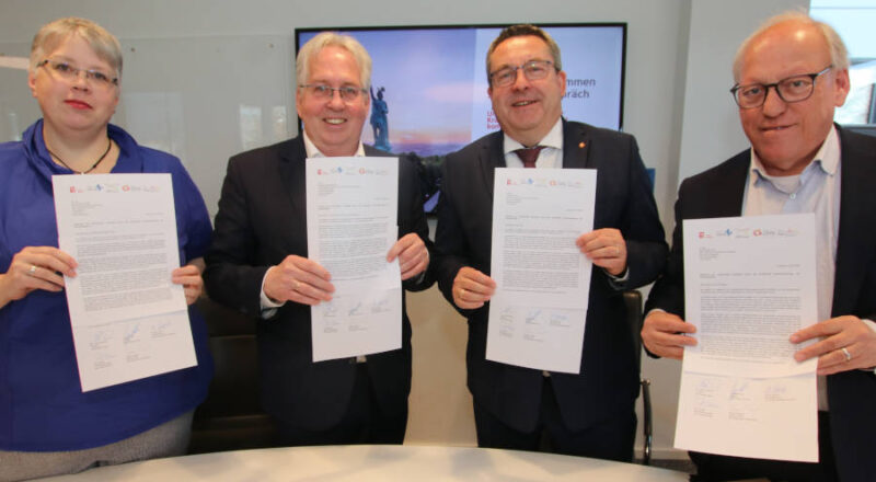 Nicole Streitz (Kreisdirektorin Kreis Minden-Lübbecke), Jürgen Müller (Landrat Kreis Herford), Dr. Axel Lehmann (Landrat Kreis Lippe) und Pit Clausen (Oberbürgermeister Stadt Biele- feld) (von links) halten die unterschriebenen Briefe in den Händen, in denen sie sich an NRW-Ministerpräsident Hendrik Wüst sowie die Bundestagsfraktionen von CDU, SPD und Bündnis 90/Die Grünen richten. Foto: Kreis Lippe