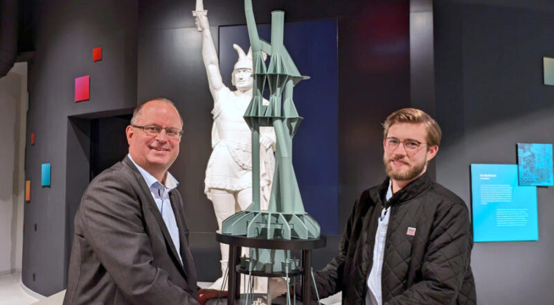 Im Hermanneum übergibt Philipp Rummeling (r.) das Miniaturmodell der Innenkonstruktion des Hermannsdenkmals an Arne Brand (Leiter der Zentralen Infrastruktur). Foto: LVL