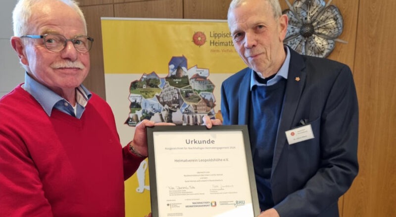 Der Vorsitzende des Lippischen Heimatbundes Albert Hüser (links) überreicht dem Vorsitzenden des Heimatvereins Leopoldshöhe Helmut Depping die Urkund für Nachhaltiges Heimatengagement 2024. Foto: Privat