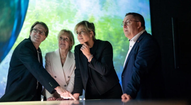 Ingo Möller (von links), Ute Röder und Landrat Dr. Axel Lehmann (rechts) zeigen NRW-Wirtschafts- und Klimaschutzministerin Mona Neubaur den interaktiven Globus bei der Eröffnung im Mai 2024. Foto: LTM GmbH, I.Fassbender