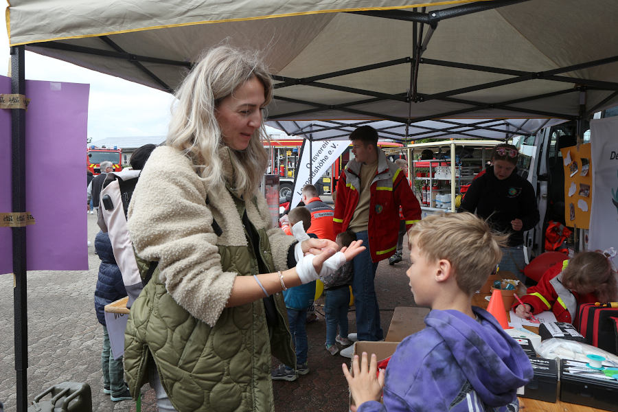 Irina Scharko begutachtet den Verband, den ihr Sohn Louis bei Station 2 der Feuerwehr-Olympiade angelegt hat. Foto: Edeltraud Dombert