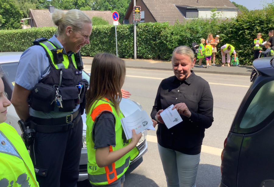 Bezirkspolizistin Nina Worm beobachtet das Gespräch zwischen Kindern und Erwachsenen bei der Denkzettelaktion. Foto: GS Asemissen
