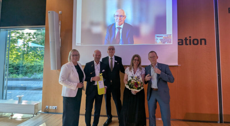 Ein Abend im Zeichen der Stärkung des Wirtschaftsstandortes Lippe und Deutschland: Svenja Jochens, Hauptgeschäftsführerin der IHK Lippe, Oliver Voßhenrich, IHK-Vizepräsident, Volker Steinbach, IHK-Präsident, Melanie Lehmann, IHK-Vizepräsidentin und Andreas Henkel, stellvertretender Hauptgeschäftsführer der IHK Lippe (v.l.n.r.) zusammen mit DIHK-Präsident Peter Adrian (auf der Leinwand). Foto: IHK Lippe