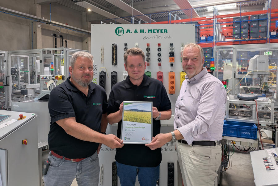 Jörg Hohmeier (Leiter Metallfertigung, links) und Marvin Berns (Geschäftsführer von A. & H. Meyer, Mitte) nehmen die Urkunde von Olrik Meyer (Fachbereichsleiter Umwelt, nachhaltige Entwicklung und Mobilität des Kreises Lippe, rechts) entgegen. Foto: Kreis Lippe