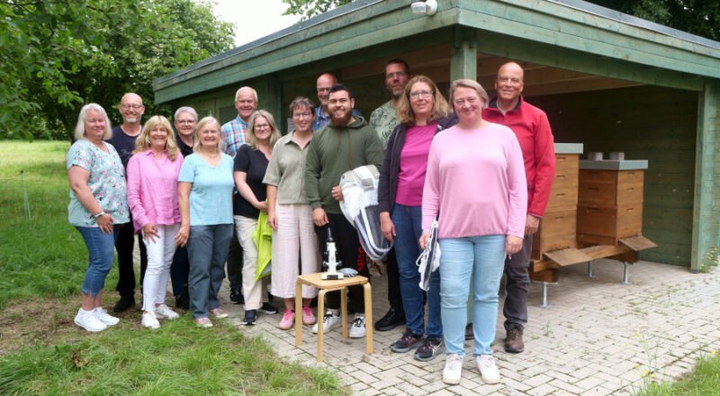 Die Teilnehmerinnen und Teilnehmer des ersten Imker-Grundkurses stehen mit den Referentinnen und Referenten am Bienenlehrstand auf dem Heimathof. Foto: Thomas Dohna