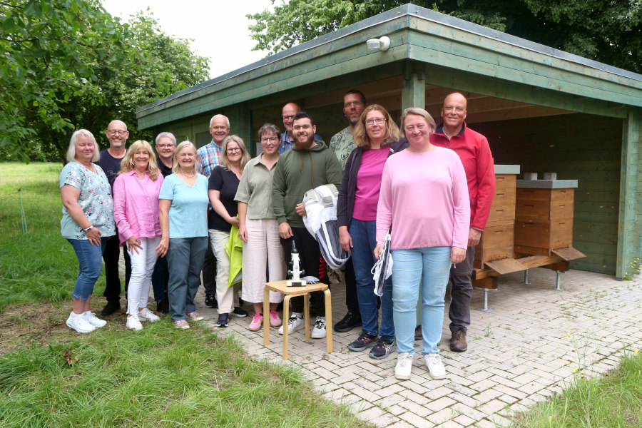 Die Teilnehmerinnen und Teilnehmer des ersten Imker-Grundkurses stehen mit den Referentinnen und Referenten am Bienenlehrstand auf dem Heimathof. Foto: Thomas Dohna