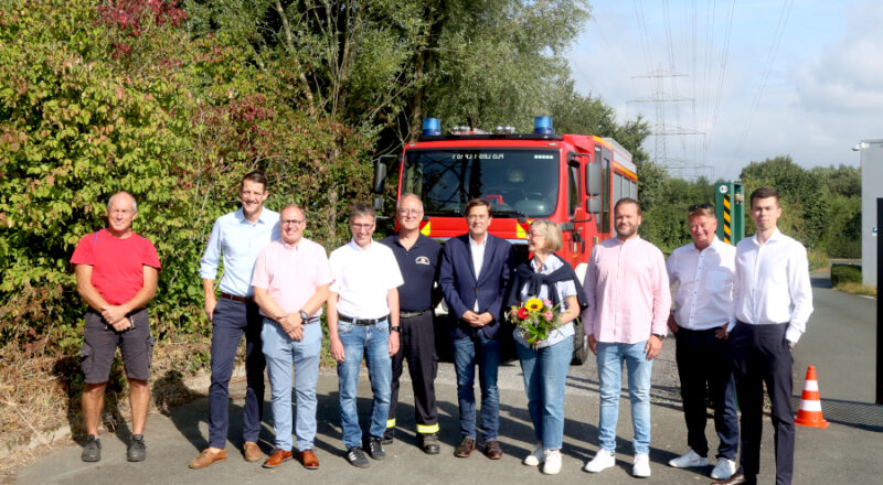 Unternehmer, Bürgermeister Martin Hoffmann (vierter von links) und Feuerwehrchef Harald Schubert (fünfter von links) freuen sich über die neue Feuerwehrzufahrt ins Gewerbegebiet Asemissen. Marie Luise Asemissen (vierte von rechts) bekam stellvertretend für die Eigentümer des Weges einen Blumenstrauß. Foto: Thomas Dohna