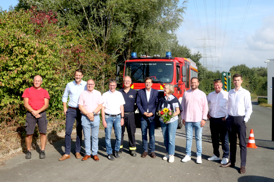 Unternehmer, Bürgermeister Martin Hoffmann (vierter von links) und Feuerwehrchef Harald Schubert (fünfter von links) freuen sich über die neue Feuerwehrzufahrt ins Gewerbegebiet Asemissen. Marie Luise Asemissen (vierte von rechts) bekam stellvertretend für die Eigentümer des Weges einen Blumenstrauß. Foto: Thomas Dohna