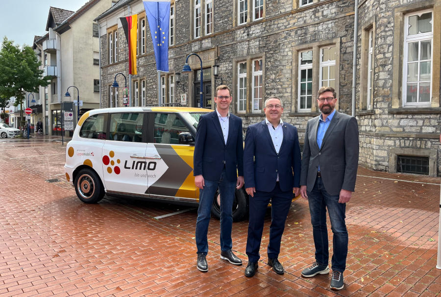 Matthias Kalkreuter, Landrat Axel Lehmann und Achim Oberwöhrmeier ( von links) freuen sich auf dem Lagenser Marktplatz über den fünfjährigen Geburtstag der Limo in Lage. Foto: Kreis Lippe