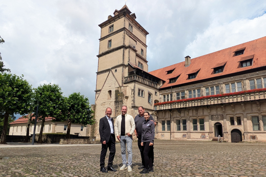 Freuen sich auch bei bestem Sommerwetter schon jetzt auf die „Lippischen Schlossnächte“, die ab 21. November 2025 im Innenhof von Schloss Brake zu erleben sind: Verbandsvorsteher Jörg Düning-Gast, Michael Nolting vom Event- und Cateringservice „Herz Ass“ sowie Daniel Kohring und Margerita Ortega vom Kohlpott (Detmold, von links). Foto: LVL