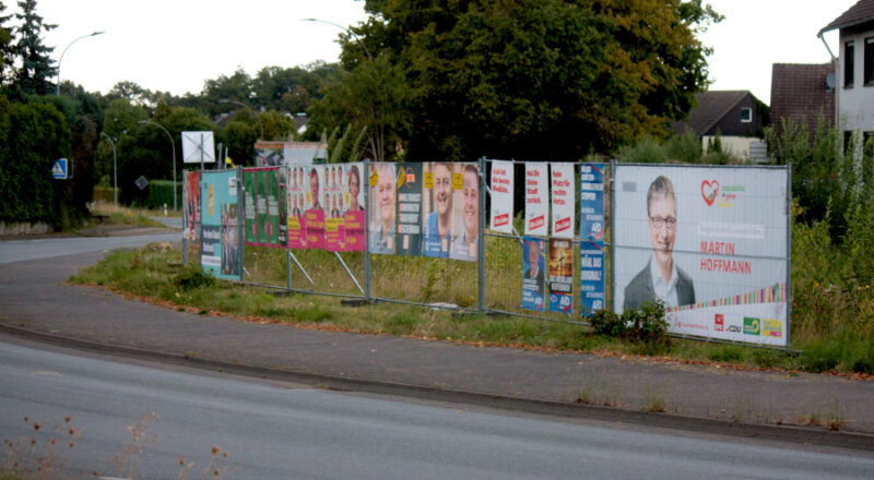 Wahlplakate für die Kommunalwahl 2025 hängen an einem Bauzaun am Fillies-Gelände in Bechterdissen. Foto: Thomas Dohna