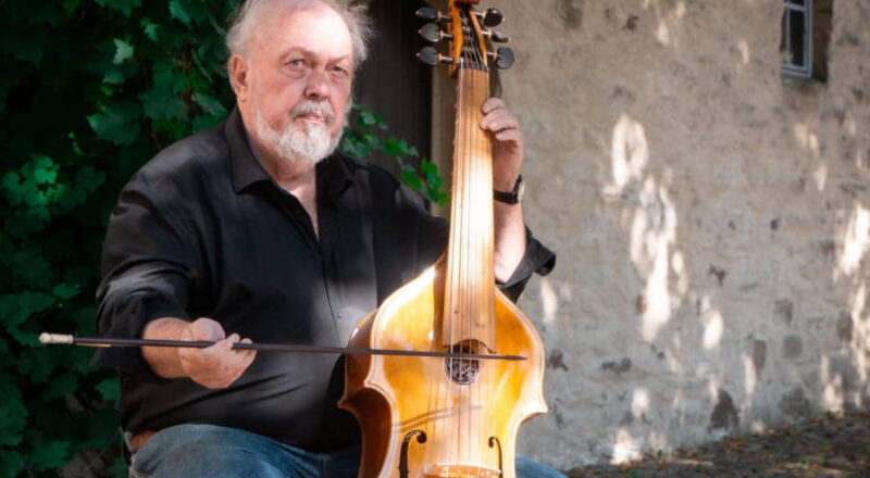 Walter Waidosch mit einer Viola da Gamba im Innenhof der Burg Sternberg. Foto: Jonas Gröger