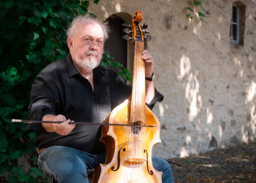 Walter Waidosch mit einer Viola da Gamba im Innenhof der Burg Sternberg. Foto: Jonas Gröger