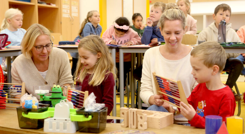 Schulleiterin Madlen Klarhorst und Lehrerin Friederike Föste (von links) probieren mit Mathilda und Alexander die neuen Materialien für den Mathematikunterricht aus. Foto: Edeltraud Dombert