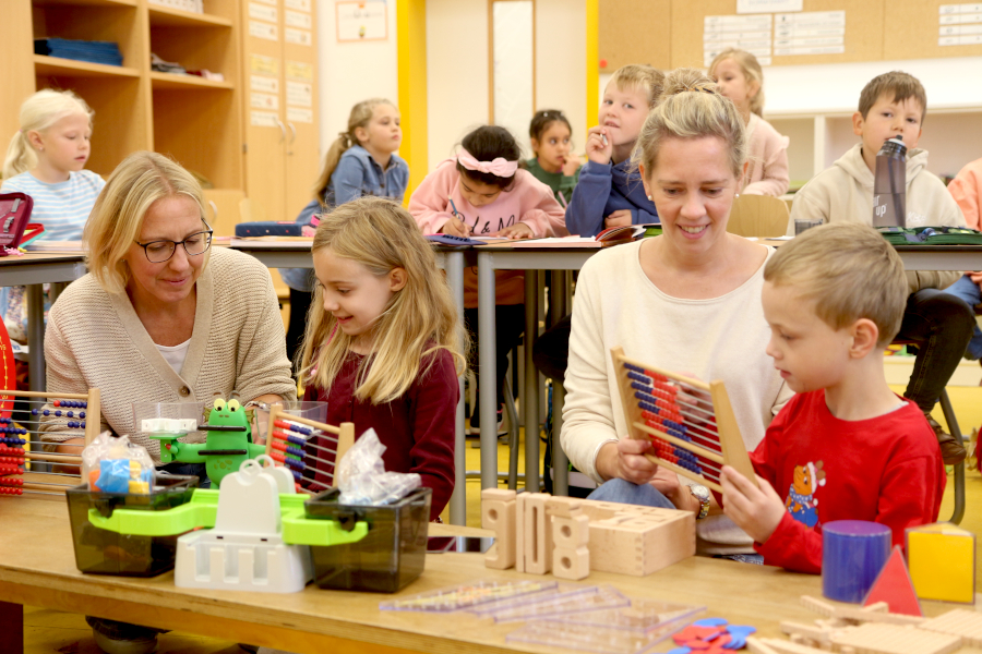 Schulleiterin Madlen Klarhorst und Lehrerin Friederike Föste (von links) probieren mit Mathilda und Alexander die neuen Materialien für den Mathematikunterricht aus. Foto: Edeltraud Dombert