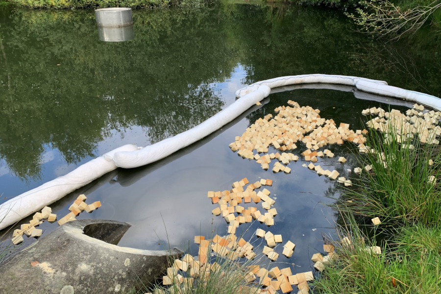 Auf der Oberfläche des Beckens schwimmen Ölschlengel und Ölbindemittel. Foto: Freiwillige Feuerwehr Leopoldshöhe
