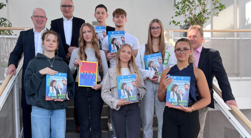IHK-Abteilungsleiter Martin Raithel, IHK-Präsident Volker Steinbach und Schulleiter Jörg Weber (von links) stellen zusammen mit Schülerinnen und Schülern des Wirtschaftsgymnasiums am Dietrich-Bonhoeffer-Berufskollegs in Detmold den neuen Ausbildungsatlas OWL vor. Foto: IHK Lippe