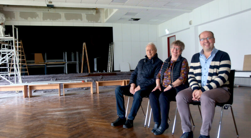 Probesitzen: Ingo Knabenreich, Ulrike Linsmeier und Ulrich Schumann (von links) vom Leos Kino Team haben schon einmal Platz genommen im zukünftigen Zuschauerraum in der Aula der Grundschule Nord. Foto: Thomas Dohna
