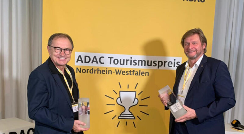 Ewald Lienen (Klimabotschafter des Kreises Lippe, links) und Günter Weigel (Geschäftsführer Lippe Tourismus & Marketing GmbH) freuen sich über den 1. Platz für das URLAND in Oerlinghausen beim ADAC-Tourismuspreis NRW. Foto: Kreis Lippe/LTM
