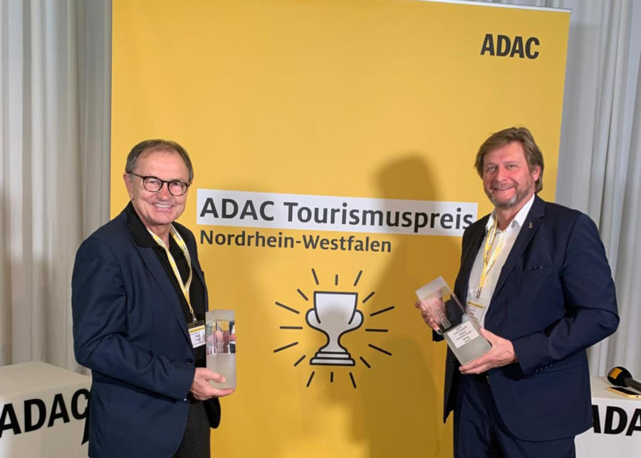 Ewald Lienen (Klimabotschafter des Kreises Lippe, links) und Günter Weigel (Geschäftsführer Lippe Tourismus & Marketing GmbH) freuen sich über den 1. Platz für das URLAND in Oerlinghausen beim ADAC-Tourismuspreis NRW. Foto: Kreis Lippe/LTM