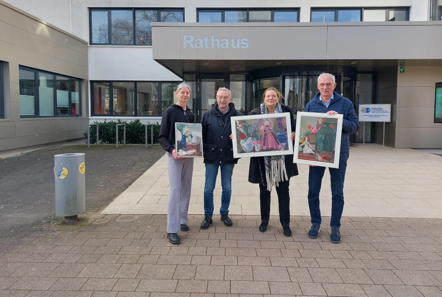 Kämmerin Almuth Mäscher (links), Bernd Hoffmann (rechts., stellvertretender Vorstand Heimatverein Leopoldshöhe) und die Gleichstellungsbeauftragte Grita Behrens freuen sich über die Bilder von Ilse Häfner-Mode, die Knut Tinius der Gemeinde Leopoldshöhe schenkt. Die drei Stillleben zeigen kunstvolle Arrangements von Alltagsgegenständen mit symbolischen Botschaften. Foto: Gemeinde Leopoldshöhe