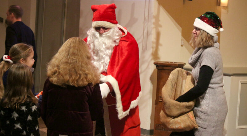 Der Nikolaus verteilt nach der Andacht Geschenke an die Kinder. Sonja Düning hilft ihm. Foto: Thomas Dohna