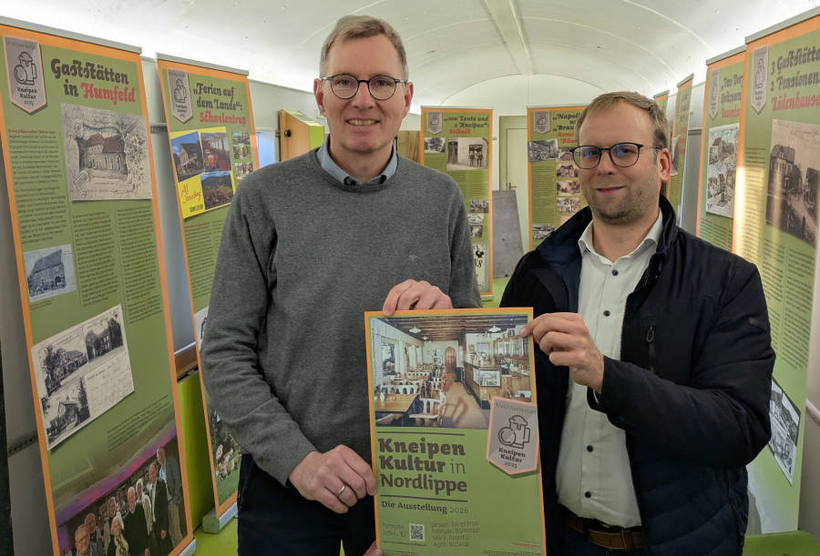 Borris Ortmeier, Bürgermeister der Stadt Barntrup und Vorsitzender der Lokalen Aktionsgruppe (LAG) Nordlippe (r.), freut sich zusammen mit Jochen Brunsiek, Geschäftsführer des Kulturstellwerks Nordlippe über die 15-teilige Wanderausstellung zur Kneipenkultur in Nordlippe. Zur Präsentation war die Ausstellung im Europawaggon am Bahnhof Farmbeck zu sehen. Nun wandert sie durch die Region.. Foto: Kulturstellwerk Nordlippe