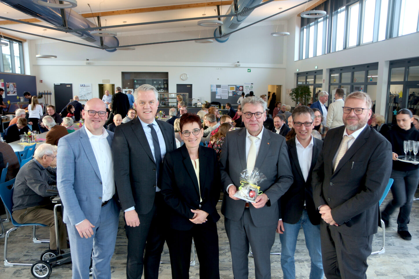 Jan Maik Schlifler (FDP Bielefeld), Tobias Jaehn und Viola Brüntrup (FDP Oerlinghausen-Leopoldshöhe), Landrat Meinolf Haase, Leopoldshöhes Bürgermeister Martin Hoffmann und Oerlinghausens Bürgermeister Peter Heepmann stehen vor den Gästen des FDP-Neujahrsempfangs in der Oerlinghauser Heinz-Sielmann-Schule. Foto: Thomas Dohna