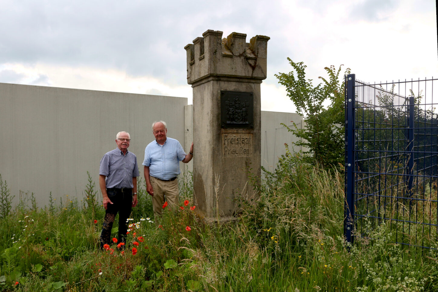 Manfred Burkamp (rechts) und der Vorsitzende des Heimatvereins Leopoldshöhe, Helmut Depping, stehen im Sommer 2025 am Grenzstein. Foto: Edeltraud Dombert