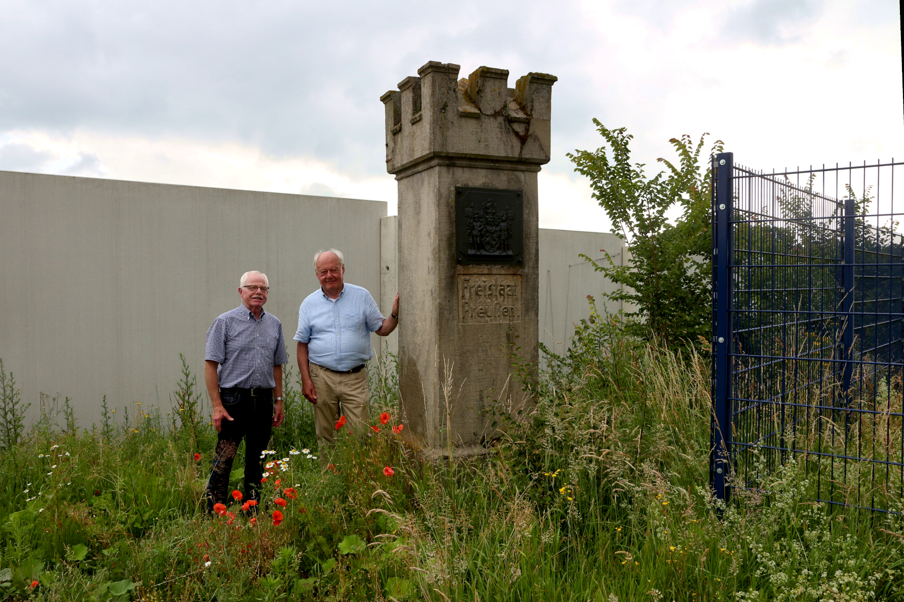 Manfred Burkamp (rechts) und der Vorsitzende des Heimatvereins Leopoldshöhe, Helmut Depping, stehen im Sommer 2025 am Grenzstein. Foto: Edeltraud Dombert