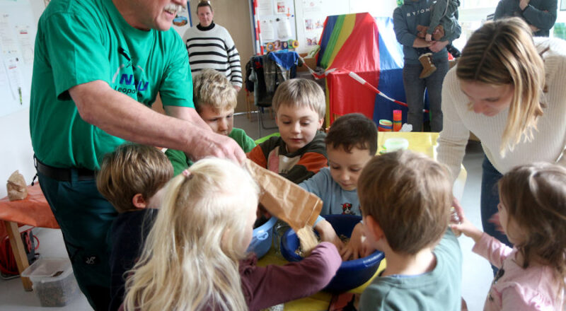 Fritz Brokbarthold (links) rührt mit den Kindern aus der Kita Greste Vogelfutter für Futterglocken an. Eifrige Helfer sind Theo, Bennet, Raphael, Marcel, Lotta (von links), Vincent und Lara (vorn) . Kita-Mutter Ruth Wacker unterstützt. Foto>: Edeltraud Dombert