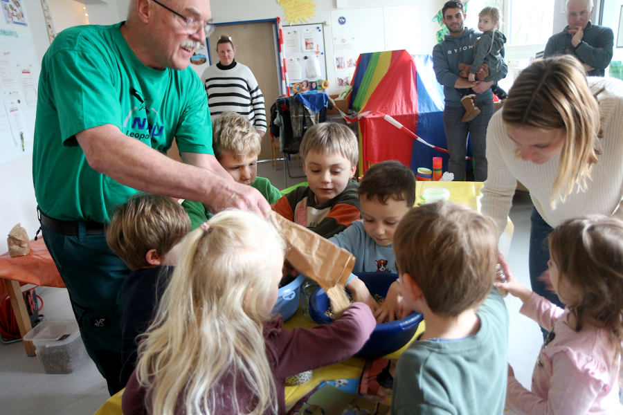 Fritz Brokbarthold (links) rührt mit den Kindern aus der Kita Greste Vogelfutter für Futterglocken an. Eifrige Helfer sind Theo, Bennet, Raphael, Marcel, Lotta (von links), Vincent und Lara (vorn) . Kita-Mutter Ruth Wacker unterstützt. Foto>: Edeltraud Dombert