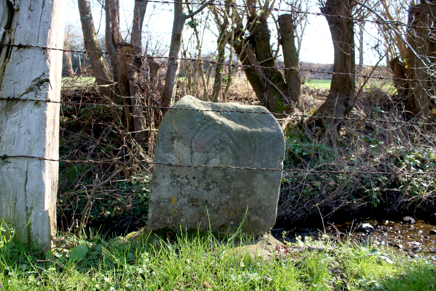 Ein historischer Grenzstein steht am Ufer. Foto: Thomas Dohna